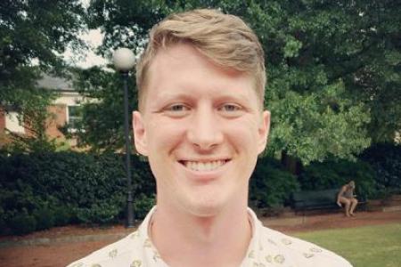 Photograph of Kyle Vanderniet outside in front of greenery